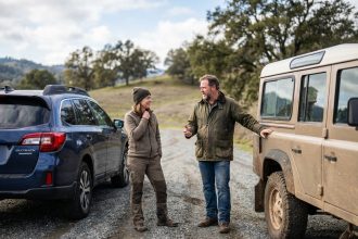 Couple discutant près de deux véhicules en campagne
