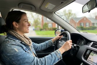 Jeune femme souriante dans une voiture moderne en extérieur